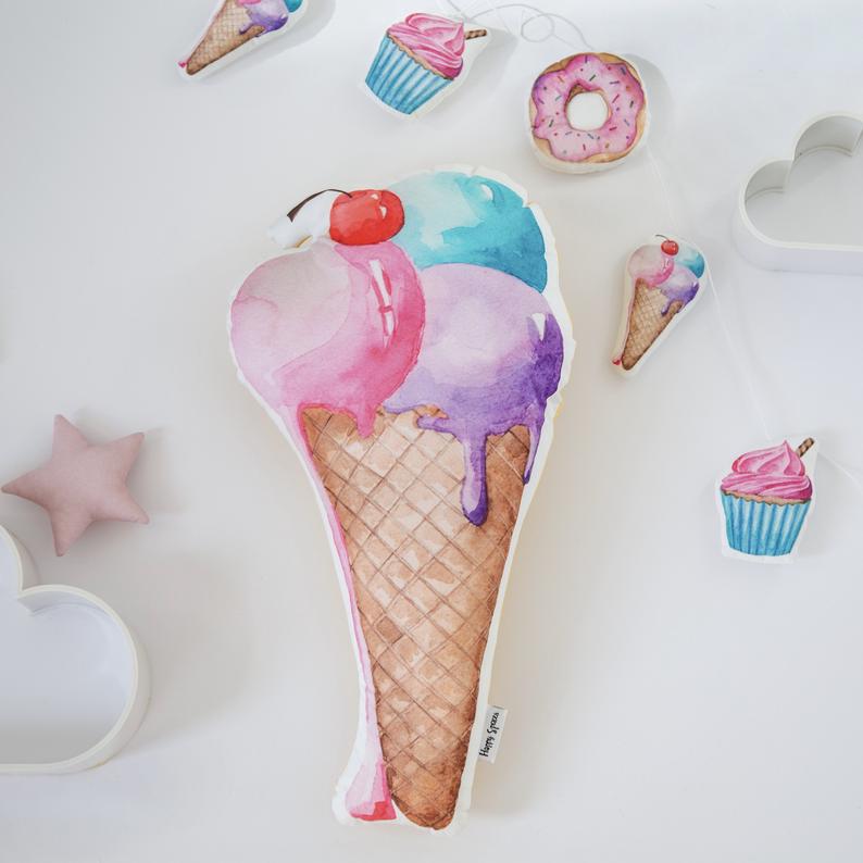 Large pillow in the shape of an icecream cone with cherry on top.