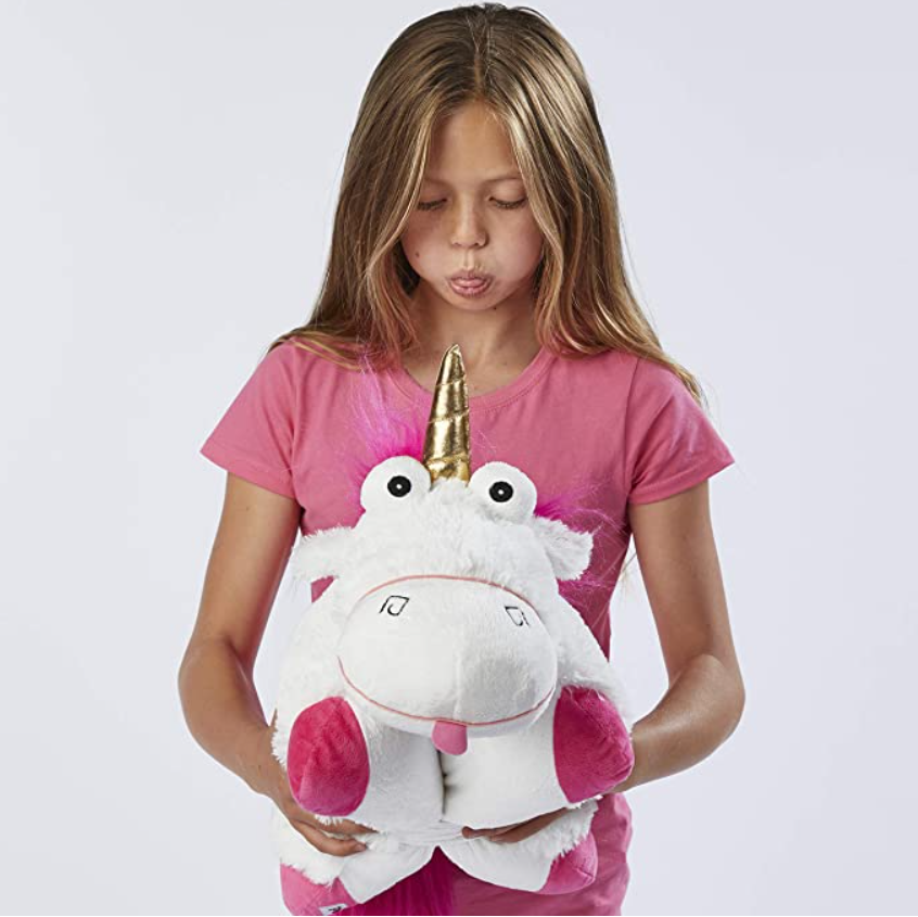 Tween girl holding a white and pink unicorn toy