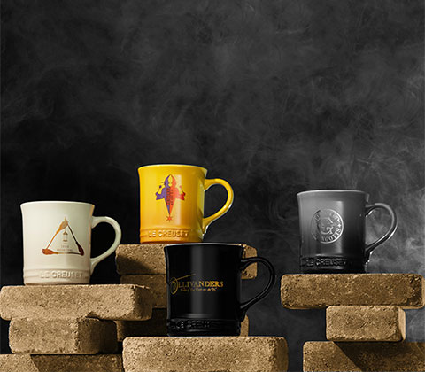 Four mugs, white, yellow, black and grey. 